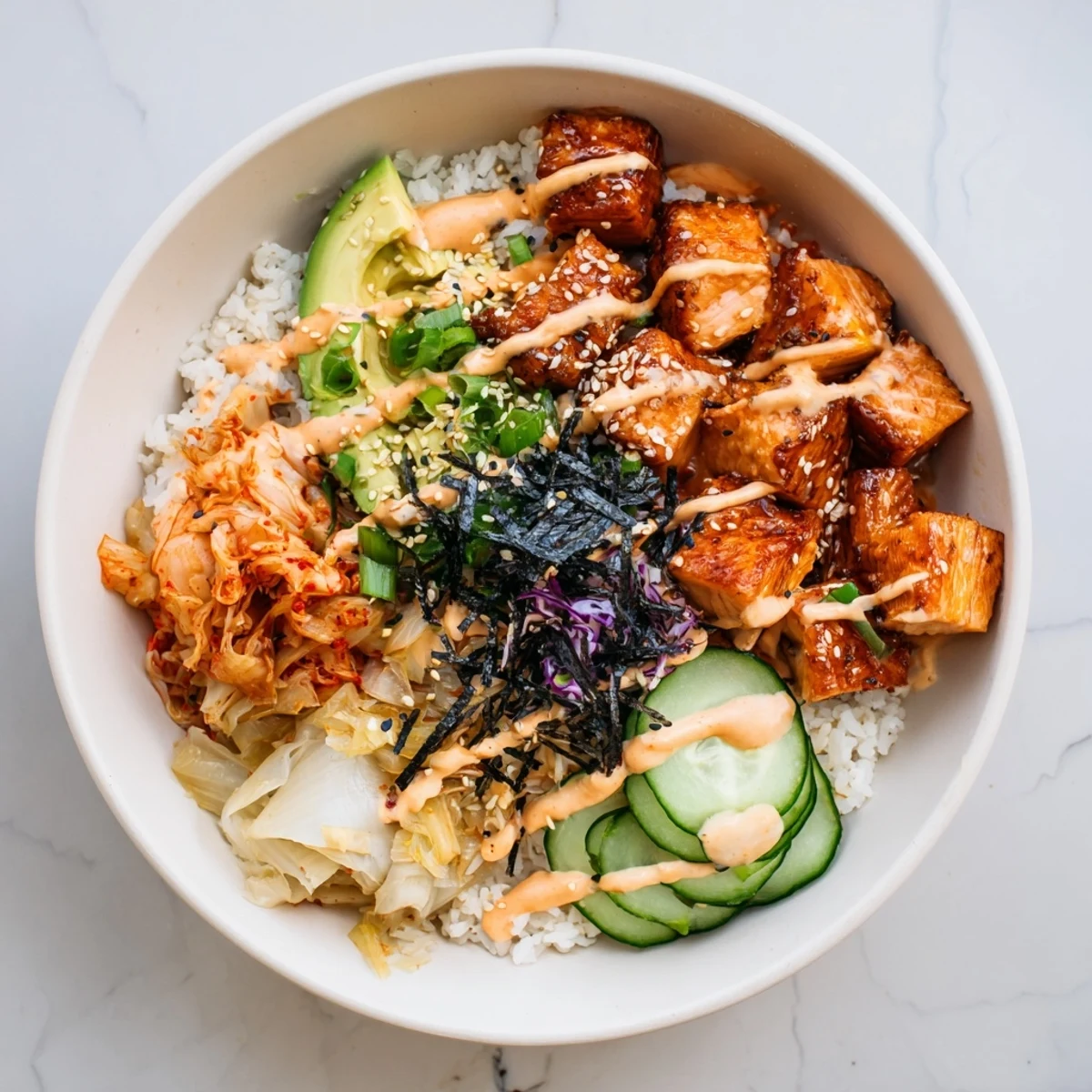 A colorful crispy salmon rice bowl topped with spicy mayo and kimchi.  