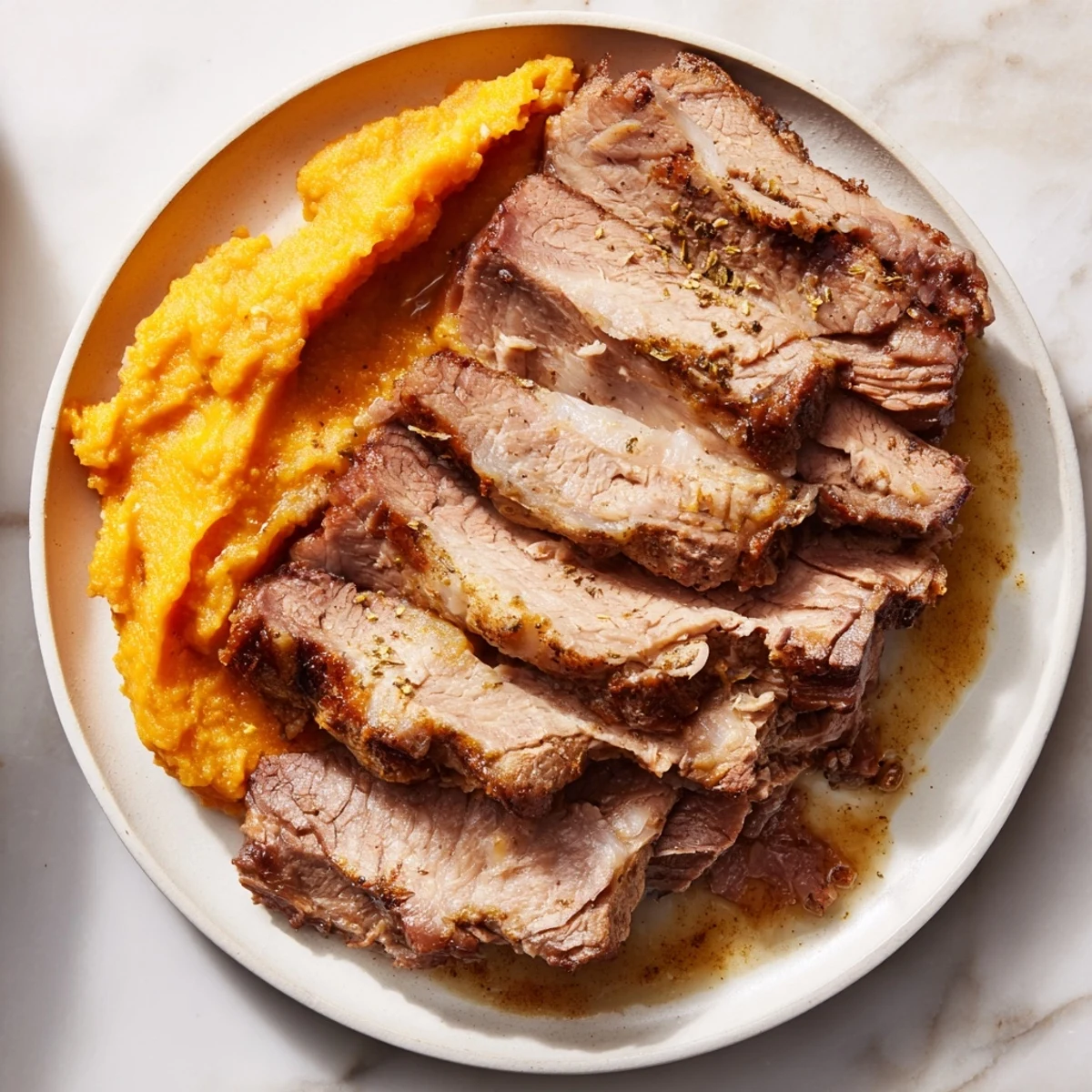 Slices of savory Classic Brisket & Mashed Sweet Potatoes are beautifully presented, a comforting family meal.