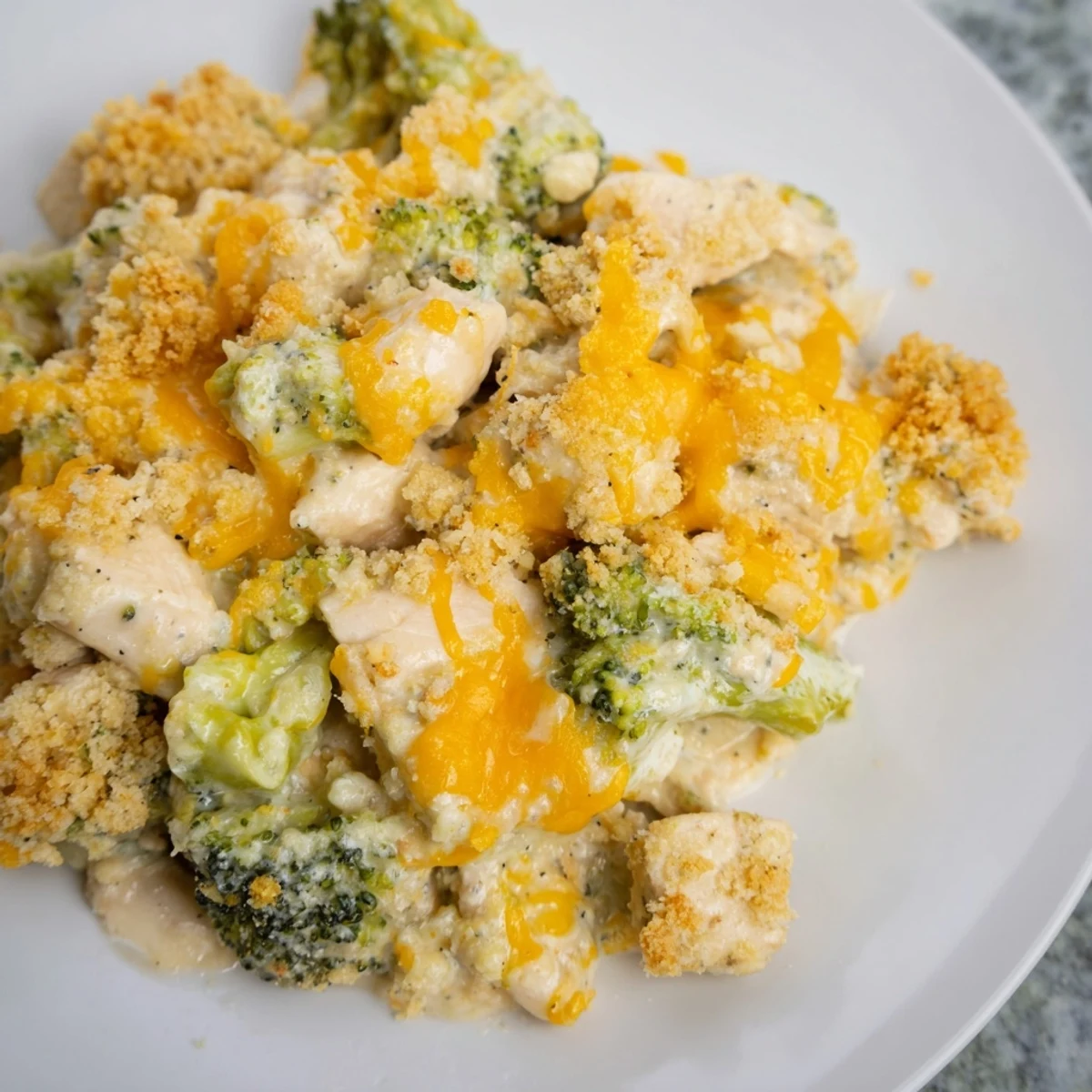 Golden, bubbling Cheddar Broccoli Chicken Bake with melted cheese and crispy breadcrumb topping, a family classic.