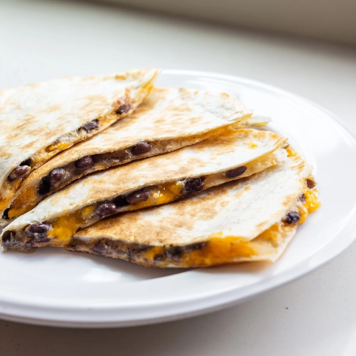 Golden-brown Bean & Cheese Quesadillas, oozing melted cheese, ready to slice and enjoy with fresh toppings.