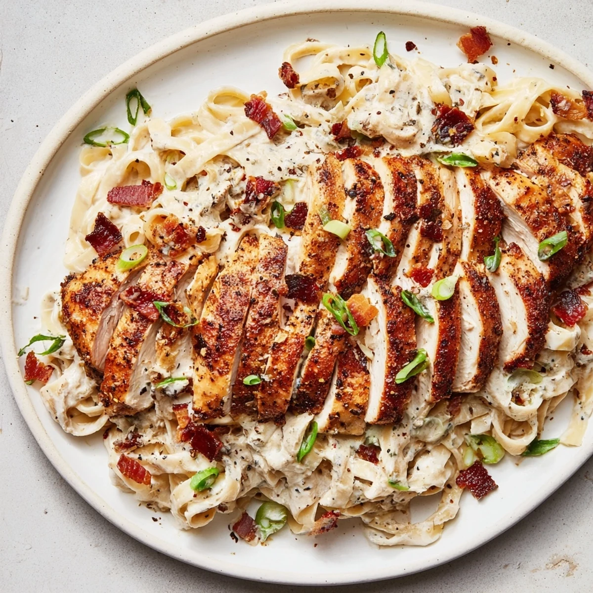 Southern Style Creamy Parmesan Chicken Pasta, featuring tender chicken strips over creamy, cheesy pasta.