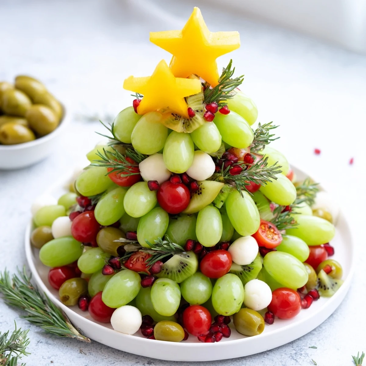A vibrant Christmas Tree Triangle Board appetizer displaying festive fruit and veggie "ornaments" for holiday entertaining.