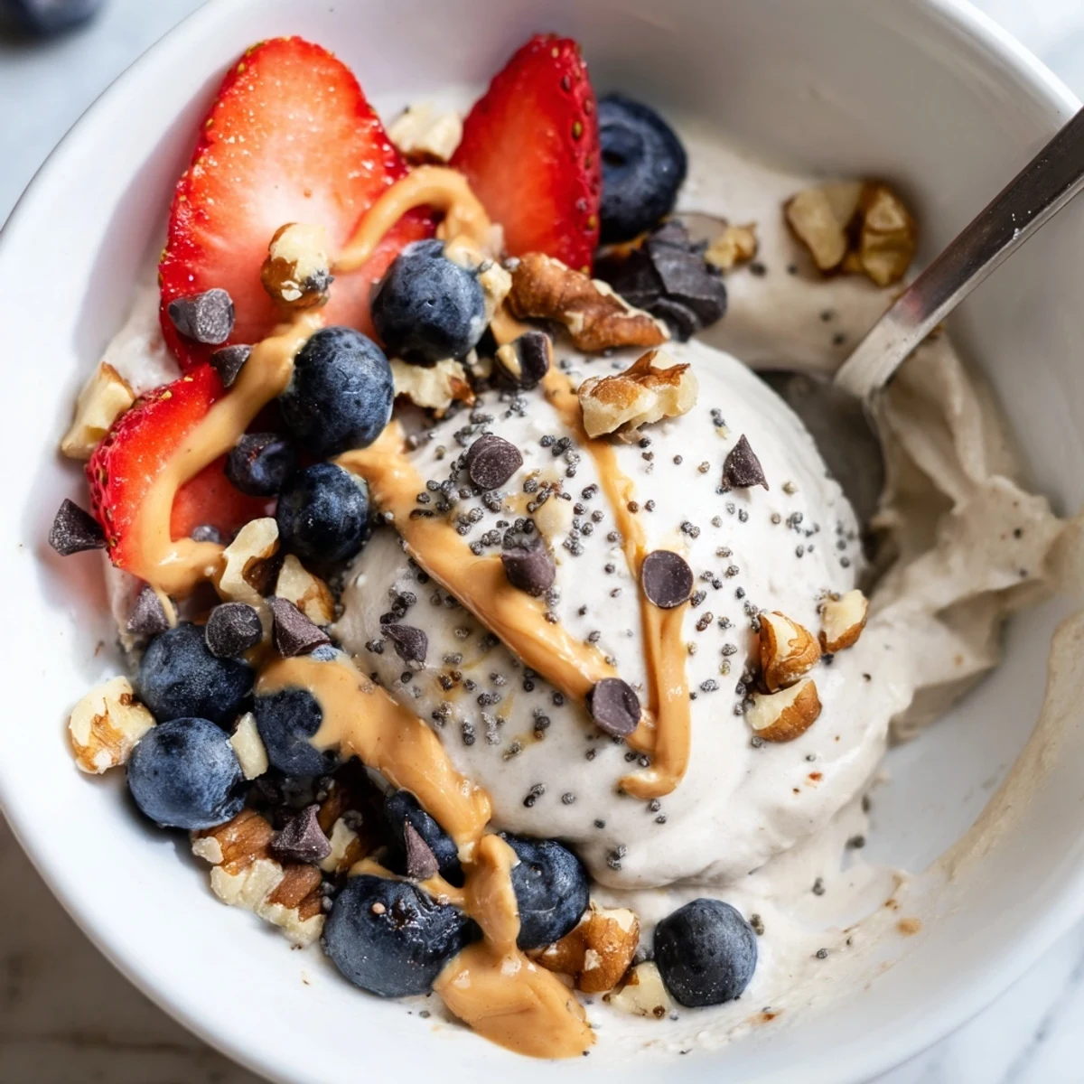 A frosty, creamy Protein Ice Cream Bowl topped with fresh berries, perfect for a healthy dessert.