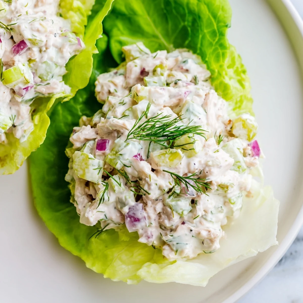 Golden-brown chopped chicken tossed with crisp dill pickles and fresh herbs, ready for stuffing into tender butter lettuce cups.