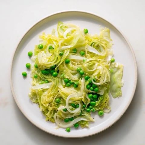 Steaming cabbage stir-fry with garlic, soy & peas, a bright veggie dish.