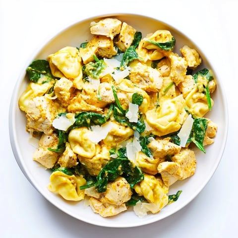 Creamy Chicken and Spinach Tortellini, a vibrant pasta dish with golden chicken and wilted spinach.