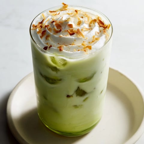 Steaming, creamy Toasted Coconut Gingerbread Iced Matcha with whipped cream, ready to refresh.
