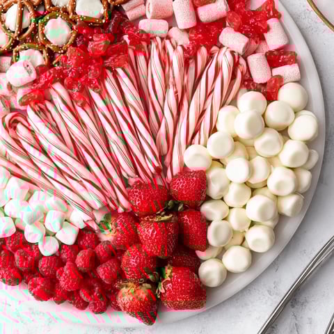 Festive Sweet Board brimming with red and white treats, ready to brighten a holiday party.