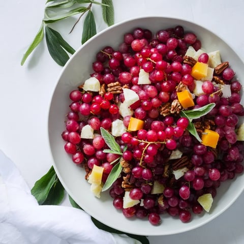 Vibrant Holly Berry Cluster appetizer platter with red berries, cheeses, and fresh herbs, perfect for a holiday feast.