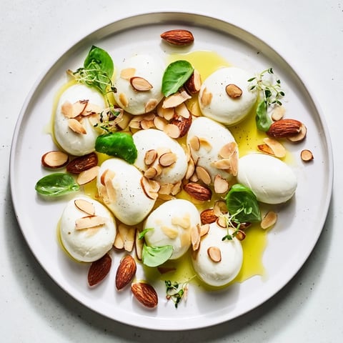 Close-up of The Polished Pebble appetizer: creamy cheeses and roasted almonds arranged like pebbles.