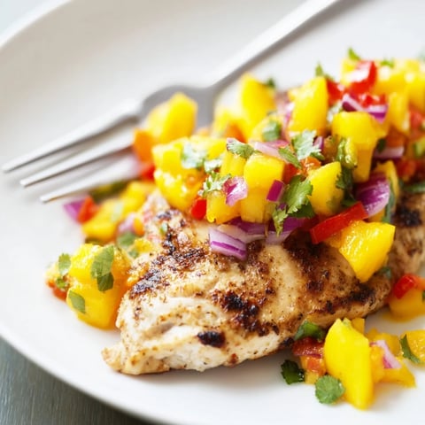 Tender Grilled Mango Salsa Chicken, a colorful medley, ready to be enjoyed with its vibrant toppings.