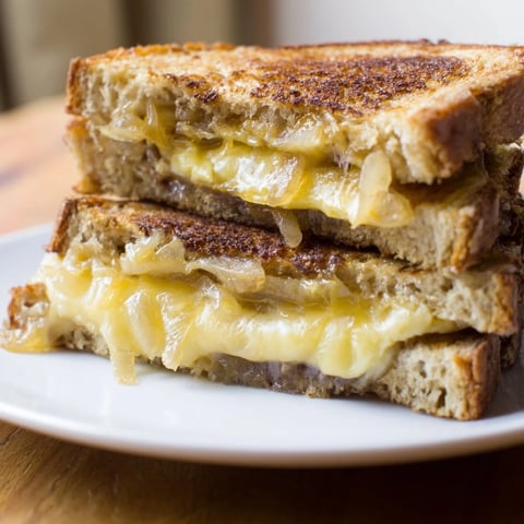 Golden, crispy Caramelized Onion and Gruyère Grilled Cheese, oozing melted Gruyère, ready to savor.