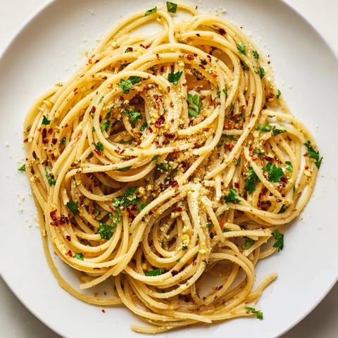 Steaming bowl of Aglio e Olio express pasta; spaghetti coated in glistening garlic-infused olive oil.