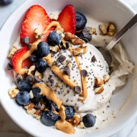 A frosty, creamy Protein Ice Cream Bowl topped with fresh berries, perfect for a healthy dessert.