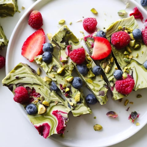 Frozen yogurt bark swirled with vibrant berries and pistachio, a delightful frozen treat perfect for summer.