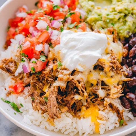 Chipotle Burrito Bowl, showcasing tender carnitas, creamy queso, and fresh salsa, ready to eat.