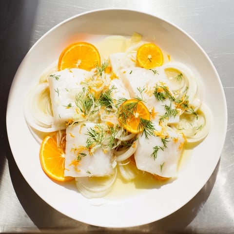 Poached cod in citrus broth with fennel, bright and flaky.