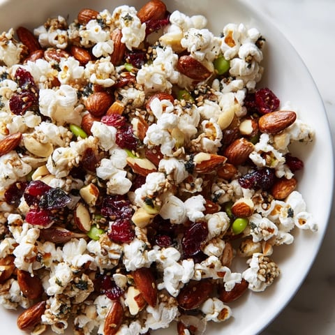 Crispy sesame popcorn and miso almonds in a festive holiday snack mix.  