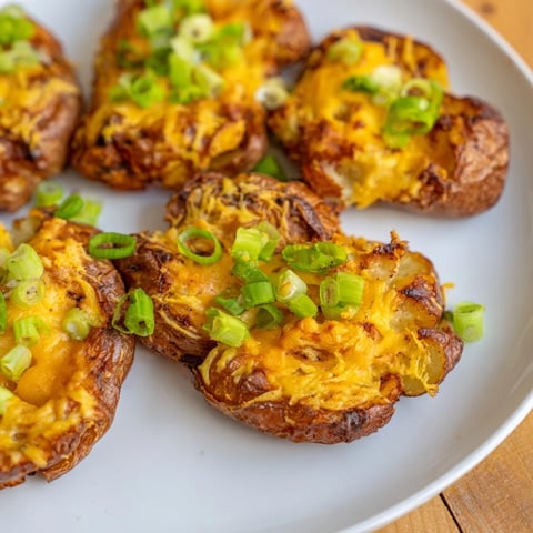 Crispy smashed green onion potato bombs topped with melted cheese and garnished parsley.