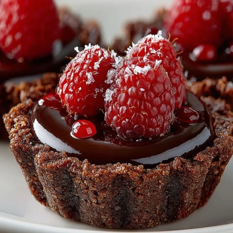 Homemade Chocolate Raspberry Tartlets: flaky crust filled with rich chocolate, ready to serve.