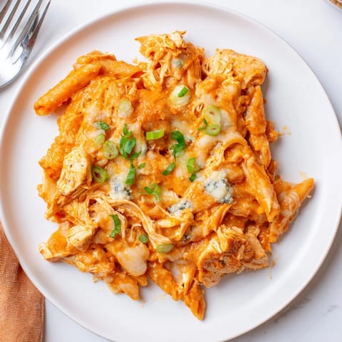 Creamy Buffalo Chicken Pasta Bake with vibrant green onion garnish, ready to serve.