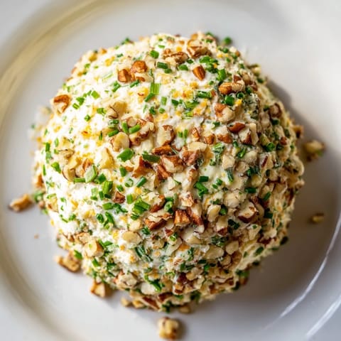 This easy-to-make Classic Cheese Ball with Ranch features a vibrant mix of herbs and crunchy nuts, perfect for parties.