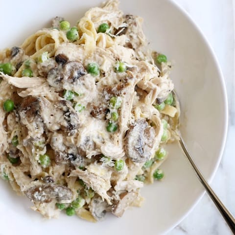 Slow-cooker Creamy Chicken Alfredo, a delectable, bubbling dish over tender, juicy chicken pieces.