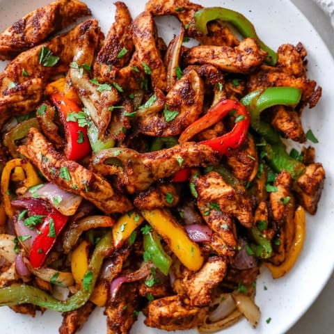 Golden chicken strips with tender vegetables, perfectly seasoned Sheet-Pan Chicken Fajitas, awaiting serving.