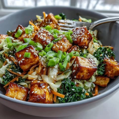 This deconstructed Tofu Egg Roll in a Bowl features sautéed kale, spinach, and a savory umami sauce drizzled over the top.
