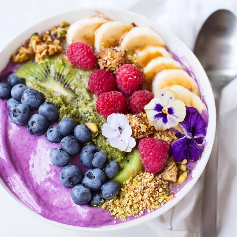 Delicious vibrant smoothie bowls featuring creamy yogurt, fresh berries, and crunchy pistachios.  
