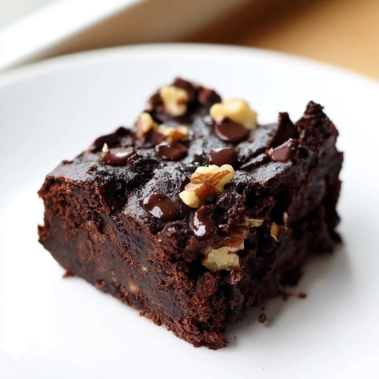 A warm, freshly baked pan of sweet potato brownies, with a rich, dark color and visible chocolate chips.